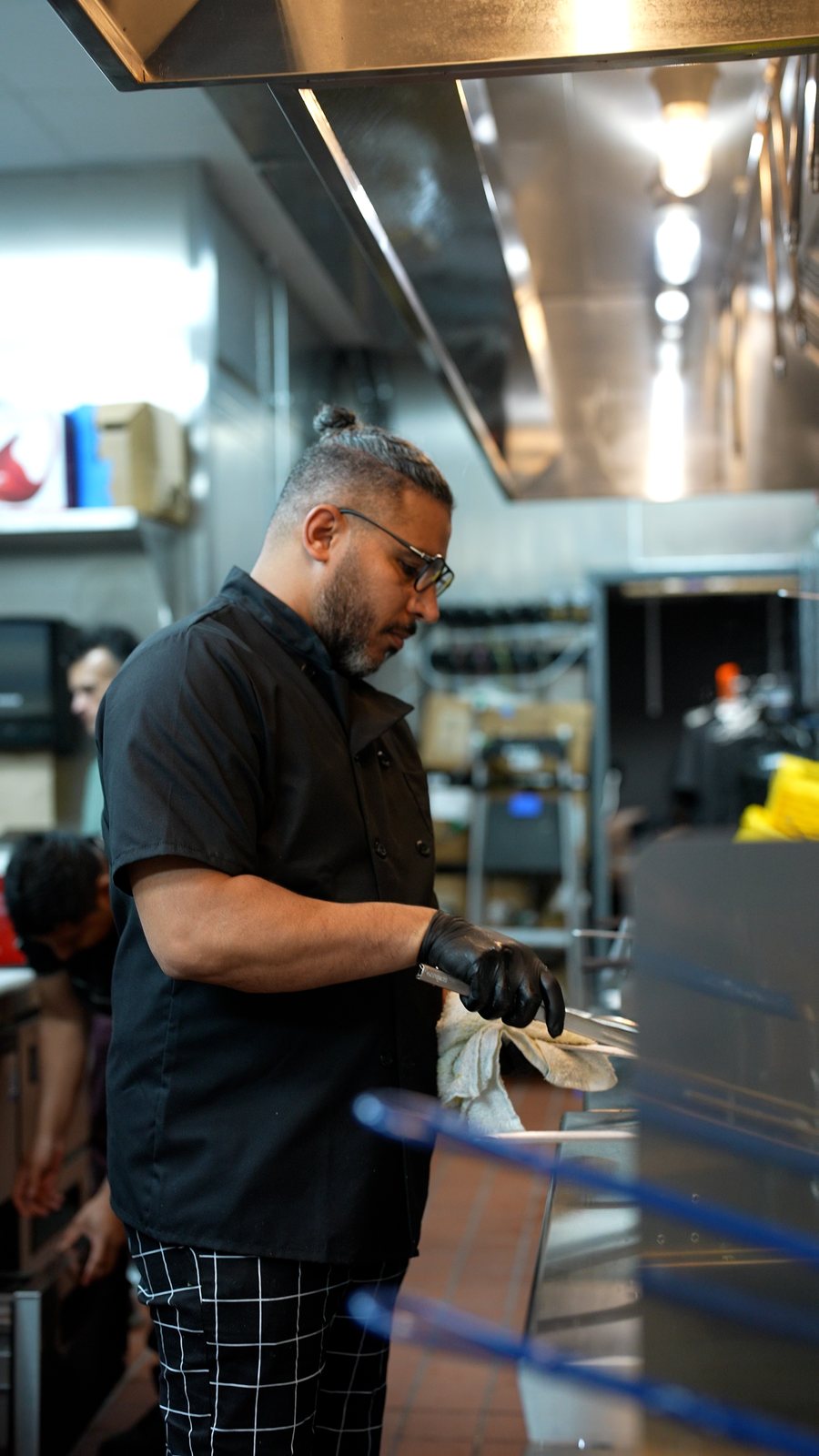 Chef Aziz at a kitchen station in gloves