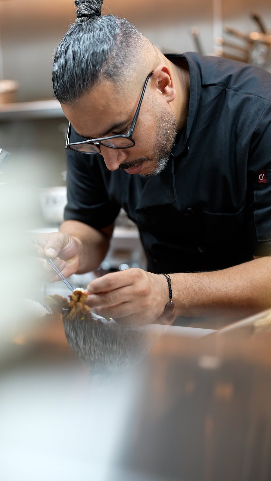 Chef Aziz plating with tweezers