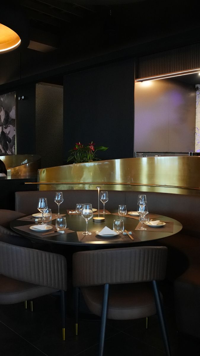 A corner banquette and bar in low light