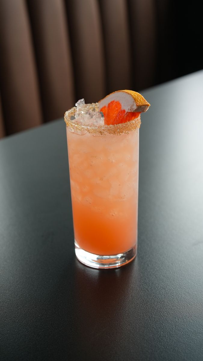 An orange cocktail with a salted rim