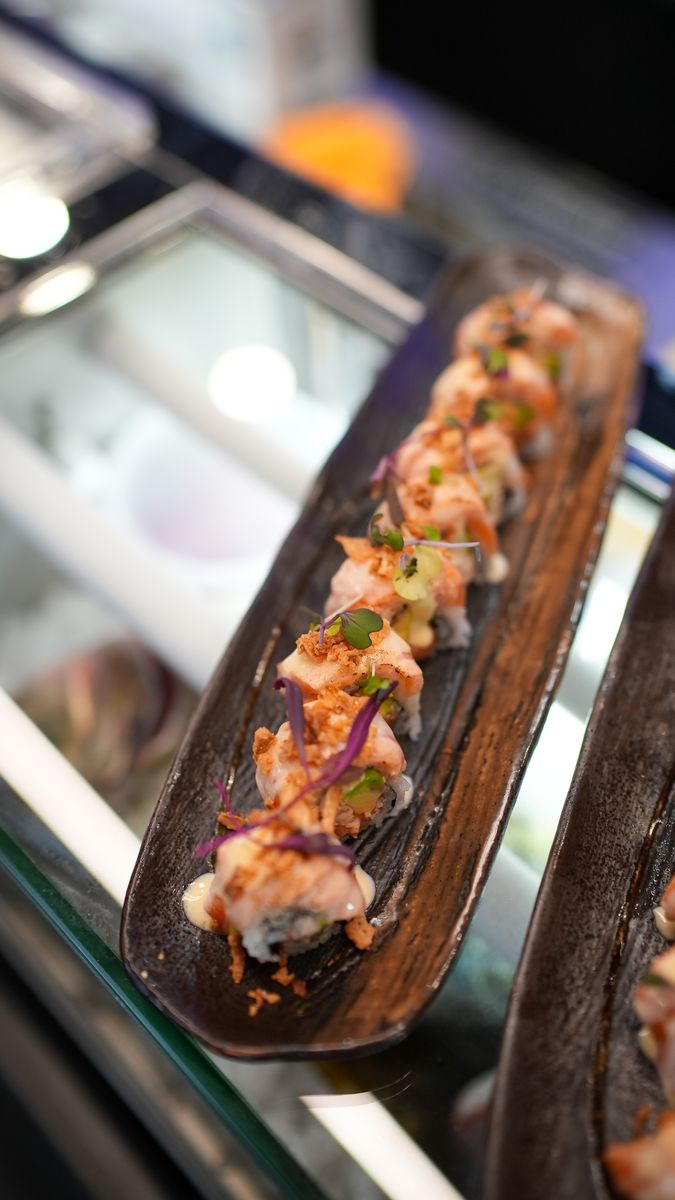 A roll on a wooden board at the sushi counter
