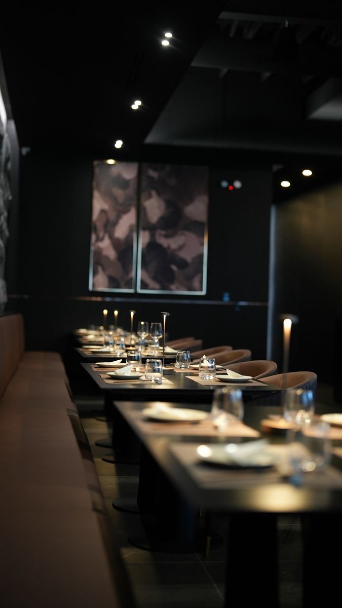 A long dining room set for service with pendant lights
