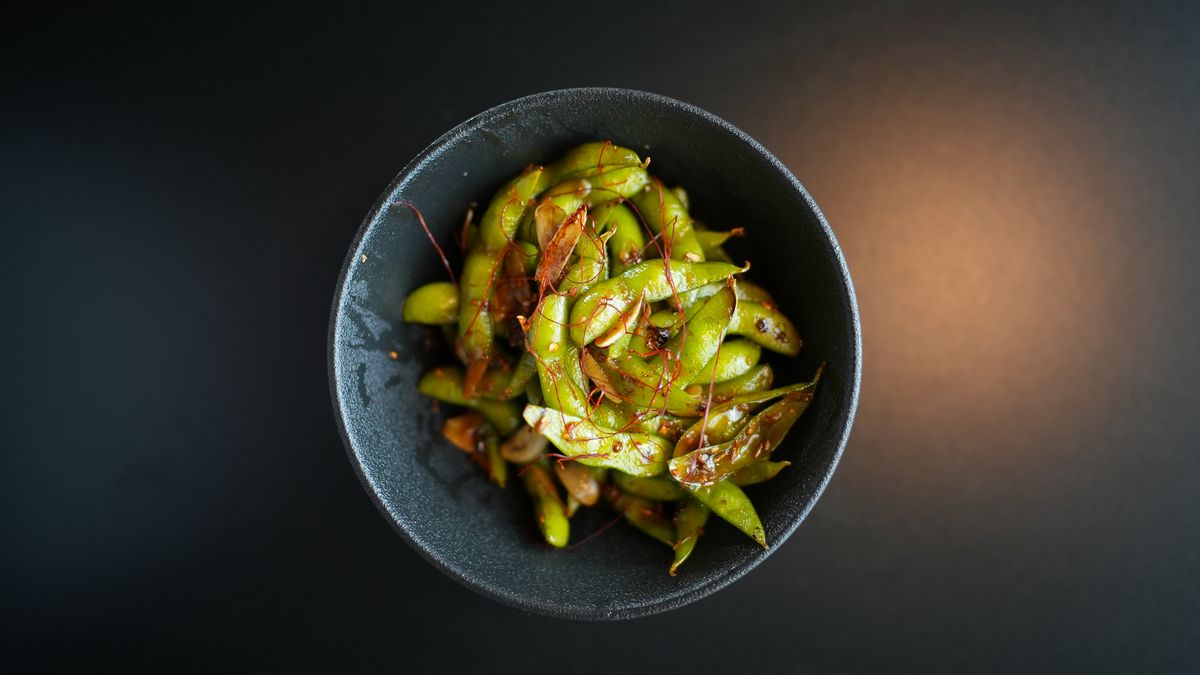 Glazed edamame in a dark bowl