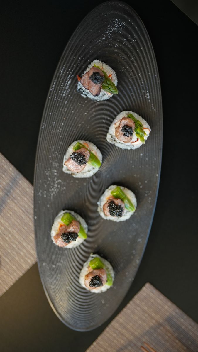 Six pieces of sushi on a long ridged plate