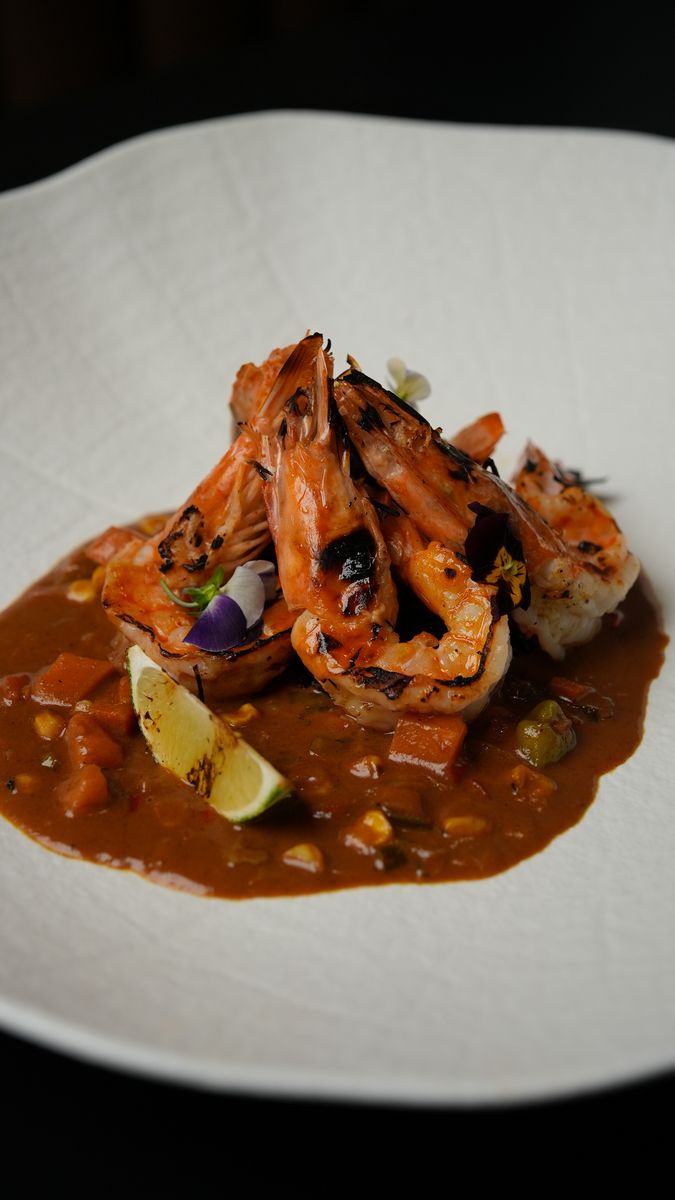 Shrimp in a dark sauce on a white plate
