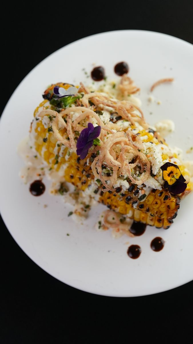 Grilled street corn under shaved cheese